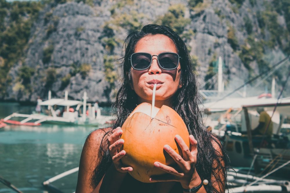 woman drinking out of a coconut