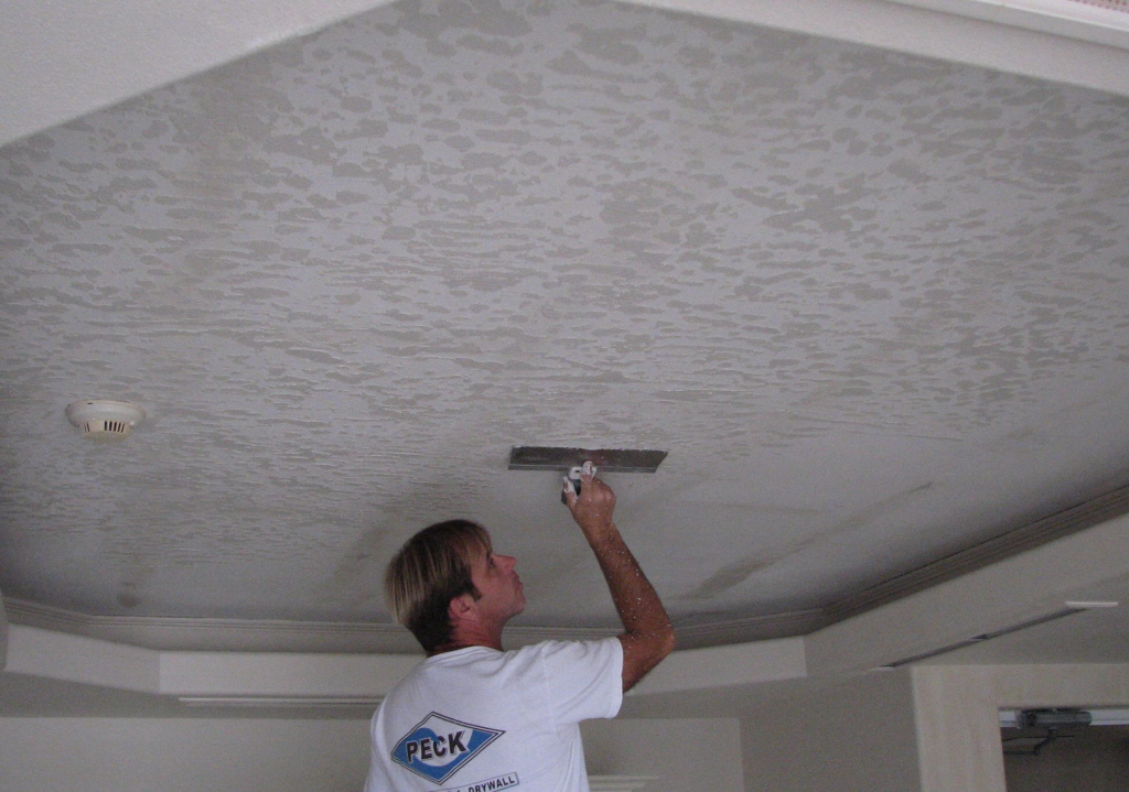 man adding texture to ceiling