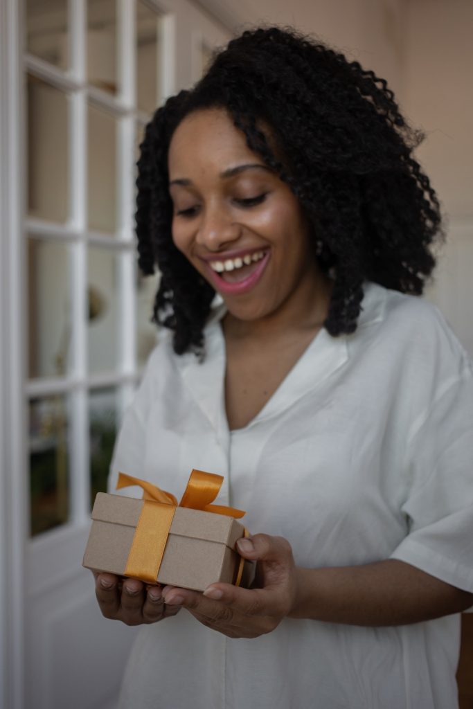 Woman with happy face receiving a wrapped gift