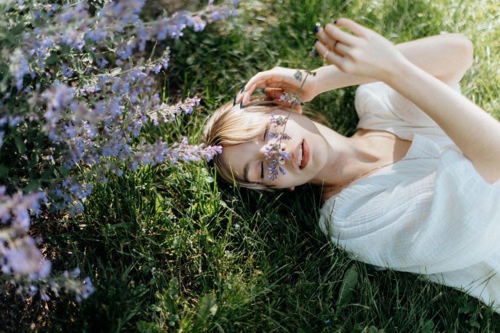 woman laying in a field of herbs