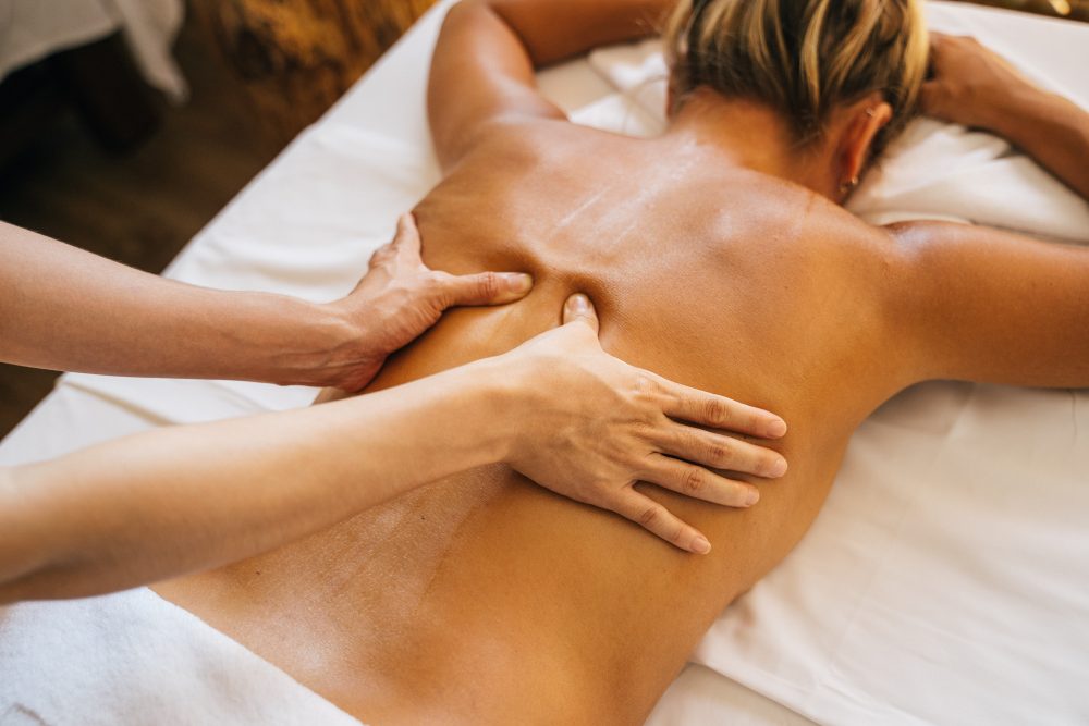 blonde woman getting massaged at spa
