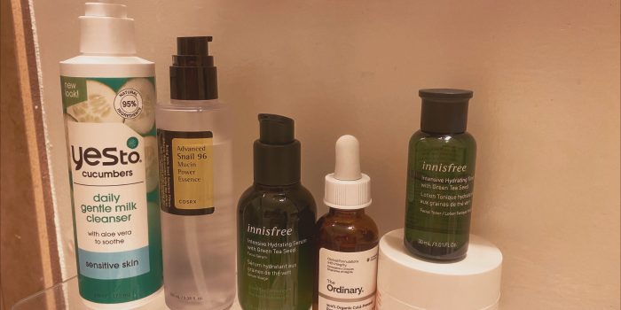 Yes To Cucumbers milk cleaners, Innisfree products, The Ordinary oil, snail essence, and Kate Somerville moisturizer on a bathroom shelf