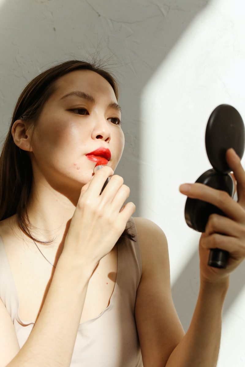 Woman applying red lipstick