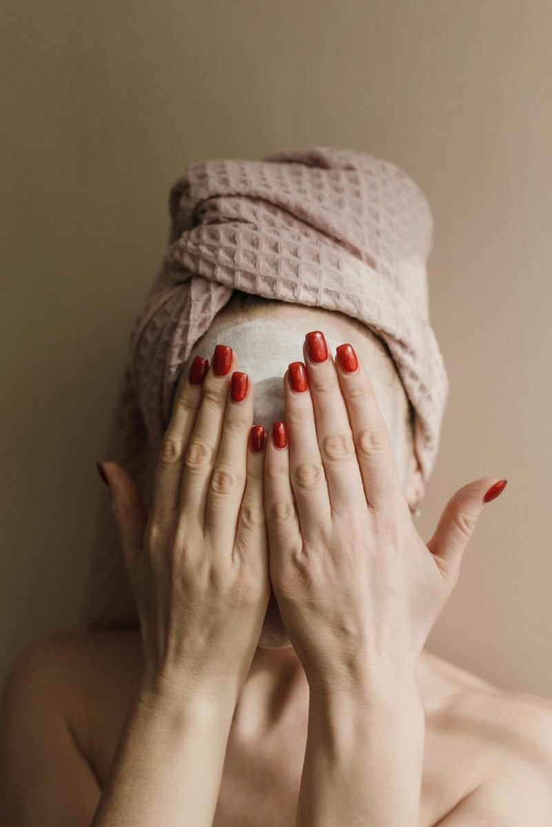 Woman with towel on her head covering her face while enjoying a clay mask on fasce