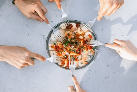 People sharing a plate of shrimp at a restaurant